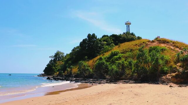 The lighthouse at Mu Ko Lanta National Park in Krabi, Thailand, standing on a grassy hill overlooking the beach and the Andaman Sea