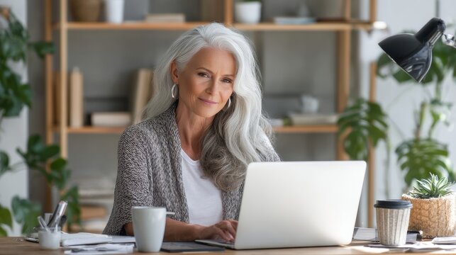 Elderly Woman with Silver Hair Using Laptop in Cozy Living Room