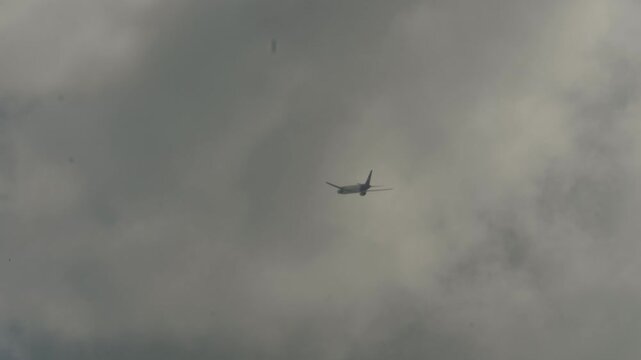 Jet airliner climbing after takeoff and passing through clouds near Singapore airport.