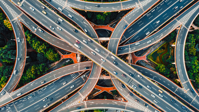 Aerial top view of complex highway interchange with traffic in modern Chinese city