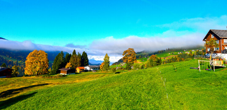 Malerische Bergh&auml;nge der Gemeinde Laterns mit herbstlichen B&auml;umen und tief h&auml;ngenden Wolken, Vorarlberg