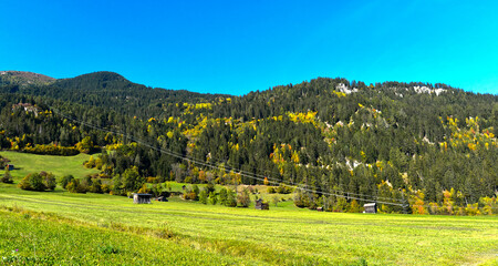 Obraz premium Herbstliche Bergwiesen mit traditionellen Heustadeln bei Prutz im Tiroler Oberinntal