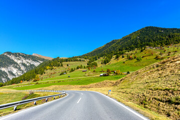 Fototapeta premium Fahrt auf der kurvigen Reschenstraße (B180) im herbstlichen Tiroler Oberinntal nahe Nauders