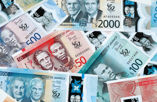 Jamaican dollar money banknotes pile on table. Jamaica bills of JMD currency close up