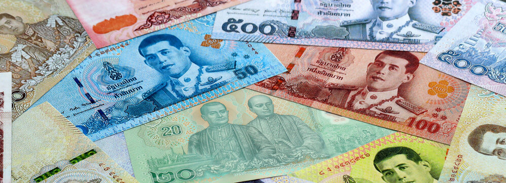 Thai baht money banknotes pile on table. Thailand bills of THB currency close up. Concept of economy
