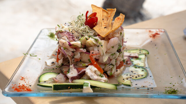 Ceviche, a typical Caribbean seafood meal. It includes light cooked squids, shrimps, sea bass fish or sliced of fish. Mix with lime juice and vinegar. Topped with scallion, sliced onions or pepper.