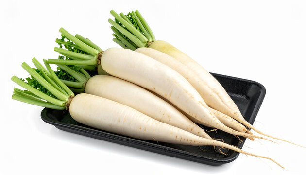 Fresh white radishes (Raphanus sativus var. longipinnatus) with green leaves on a black tray, isolated on a white background. Organic vegetable image is for food, cooking, and health projects.
