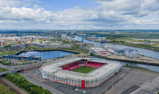 Middlesbrough Town Football Club Riverside Stadium beside the River Tees, looking towards the Transporter Bridge and city skyline.