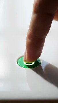 Finger presses green button to activate device
