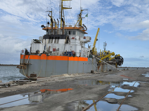 suction dredge ship moored in port. make deeper canals and harbor area. use special equipment for suction ground