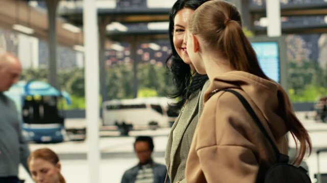 Bus station travelers, small family relocating, waiting on intercity coach for affordable long-distance journey. Gen Z teen and her mother leaving for job trip, walking in terminal hall.