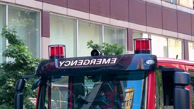 The cabin of Georgian red fire truck, fire engine on the street. Red signal lights on the vehicle are flashing. Emergency, urban, transport, accident and firefighting concept