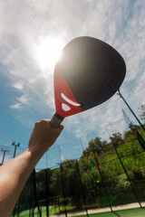 Close up Padel players hand on court background. Open social tour template. Padel tennis player on the sky background outdoors. Paddle tenis template for bookmaker design ads with copy space. © Mike Orlov