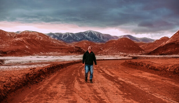 Dramatic storm clouds gathering over massive red rock formations in the high-altitude Andean desert.