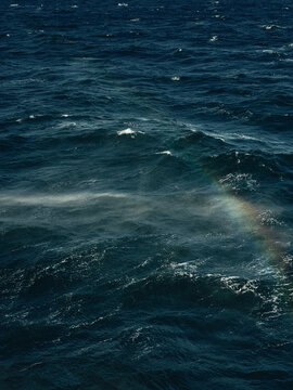 waves, spray and rainbow on stormy seas