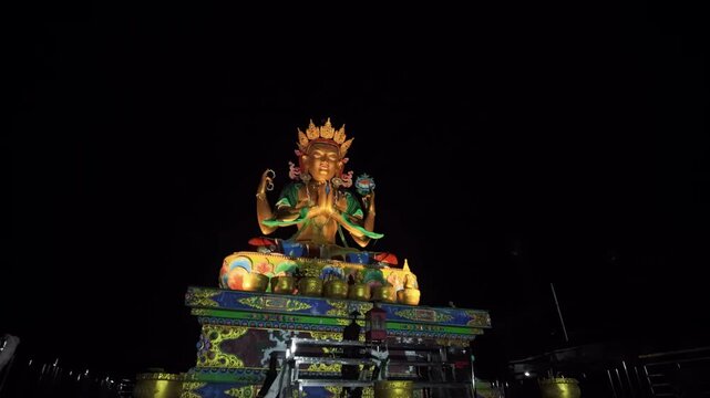 Drone aerial night footage of golden Chenrezig (Avalokiteshvara) statue in Chitrey, Nepal, Himalayas, Nepalese Himalayas, spiritual Buddhist landmark in Singalila region.