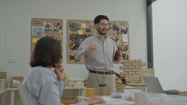 Office meeting presentation with man and woman discussing brainstorming around table, coworker teamwork workspace interior, startup product prototype collaboration and speaking session with laptop