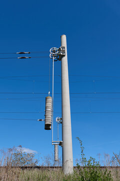 Transportation / Railway: Wire tensioners at two modern catenary posts at an electrified railroad track in Central Germany