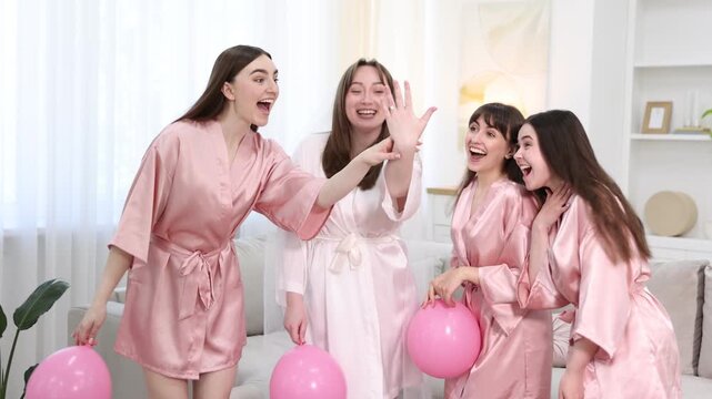 Bachelorette party. Group of women in bathrobes with balloons having fun indoors