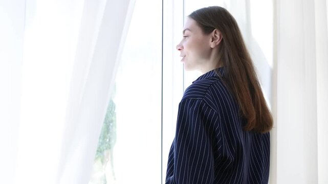 Smiling woman opening beautiful window curtains at home. Camera moving forward and backwards