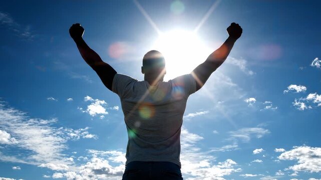 Rear view of silhouette successful project manager standing with arms outstretched facing the bright sun and blue sky, concept for career achievement, leadership inspiration and future vision