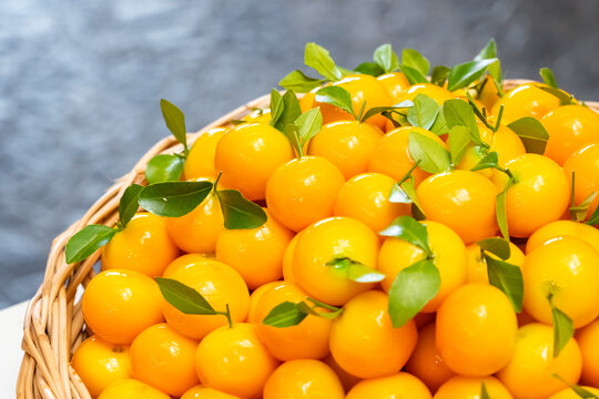 Luk Chup or Look Choop, the marzipan mung beans dessert in Thai style, molded in miniature orange fruit shape arranged in wicker basket.