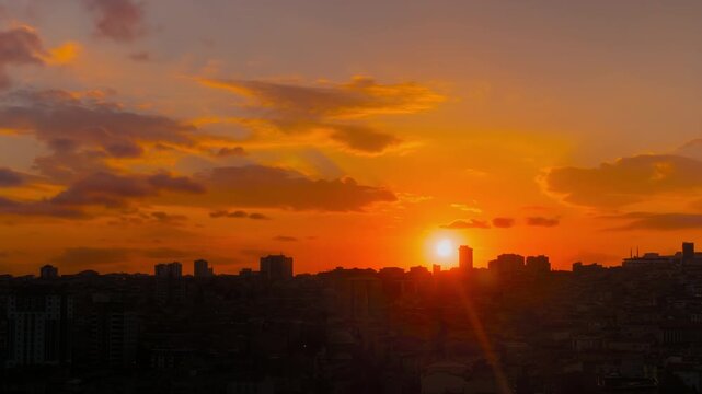 Timelapse: amazing sunset sky with the setting sun and moving clouds over the city of Istanbul in the evening - residential buildings silhouettes, getting darker. Cityscape and time lapse concept