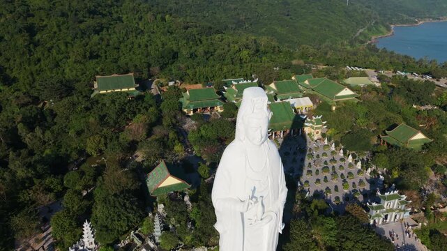 Vietnam, Da Nang Aerial Lady Buddha Statue In Da Nang Overlooking Lush Forest And Green Temple Roofs, Serene White Sculpture On Hilltop, Monastery Courtyard With Pagodas, Panoramic Ocean