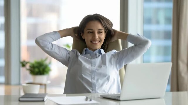 窓際の明るいオフィスで白いシャツを着た女性が背もたれに寄りかかりながら静かに休息する穏やかな時間