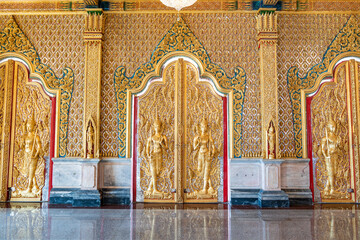 Fototapeta premium High relief guardian figure temple door Prasat Thong Kham Kanchanaphisek golden palace Wat Chantharam, ThaSung UthaiThani Thailand gilded ornament mirrored mosaic.