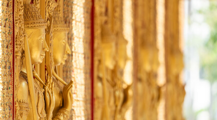 Fototapeta premium High relief guardian figure temple door Prasat Thong Kham Kanchanaphisek golden palace Wat Chantharam, ThaSung UthaiThani Thailand gilded ornament mirrored mosaic.