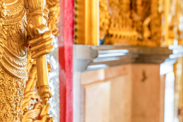 Fototapeta premium High relief guardian figure temple door Prasat Thong Kham Kanchanaphisek golden palace Wat Chantharam, ThaSung UthaiThani Thailand gilded ornament mirrored mosaic.