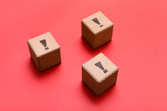 Wooden cubes with exclamation marks on red background