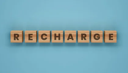 Fototapeten Positive Typografie Recharge Energy Recovery Concept Displayed Through Wooden Letter Blocks Symbolizing Renewal Motivation Productivity Restoration Wellness Balance And Performance Improvement  © Grid Byte Studio