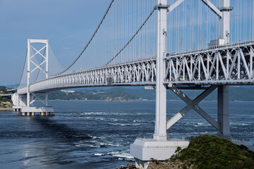 Naklejka premium 大鳴門橋のダイナミックなトラス構造と渦潮の風景（鳴門海峡）