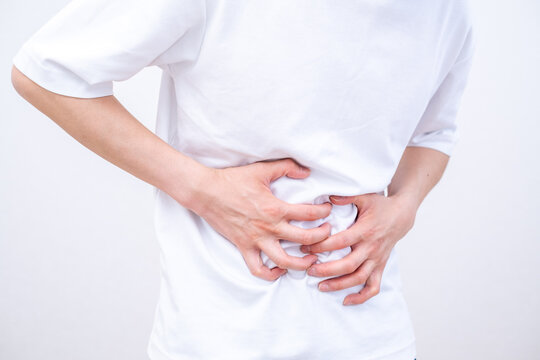 腹痛でお腹を押さえる男性
