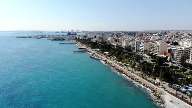 Aerial view of Limassol coastline with Molos promenade and blue mediterranean sea on sunny day.