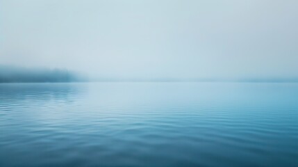Obraz premium Thick fog parting to reveal clear still blue lake, soft morning light, minimalist landscape, mental clarity metaphor, off-center, vast empty sky for text.