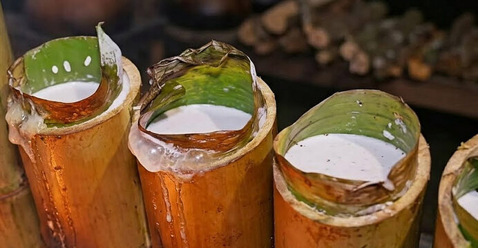 lemang sticky rice being cooked in bamboo