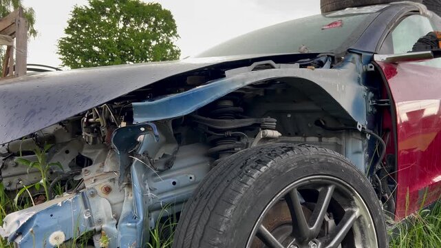 Electric car junkyard. Car beyond repair after accident. Car rusting in junkyard. Scrap metal being recycled. Dismantling of spare parts, scrap metal recycling.