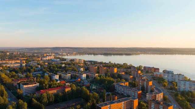 Russia, Votkinsk. Embankment with a dam and factories. Votkinsk is a city in the Udmurt Republic. Sunset time. Drone footage