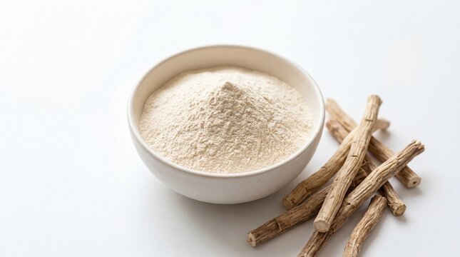 A ceramic bowl filled with fine ashwagandha root powder beside several dried woody herbal root.