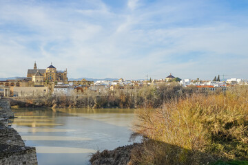 Obraz premium Historic center of Cordoba,Spain,Historic cityscape with river and ancient architecture under a clear sky