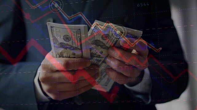 A businessman holding stacks of US dollars with a complex, downward-trending red stock market graph overlaid