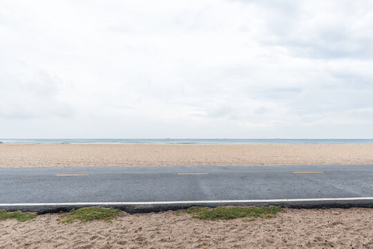 Side view of asphalt road with beach on sea and beautiful sky.