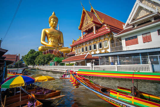 Wat Paknam Phasi Charoenbuddhist Temple golden buddha statue with wooden travel boat river side
