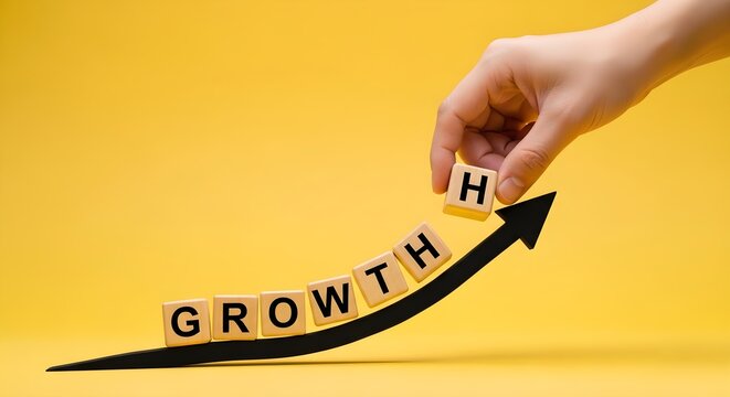 Hand placing a wooden block with the letter h onto a rising arrow to complete the word growth in this bright and professional conceptual business photo