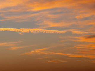 Fototapeta premium Soft orange sunset clouds in peaceful evening sky background