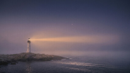 Fototapeta premium Glowing Lighthouse Radiating Hope through Dense Twilight Fog over Rocky Coastal Sea Perfect for Brochure and Event Backdrop