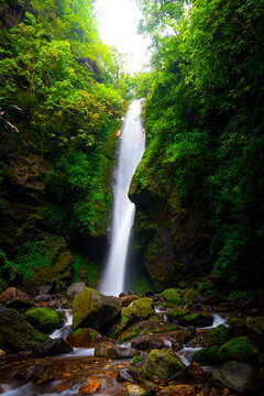 Kanchenjunga Waterfall in West Sikkim, India - A majestic, gushing cascade flowing through lush Himalayan greenery and mossy rocks.